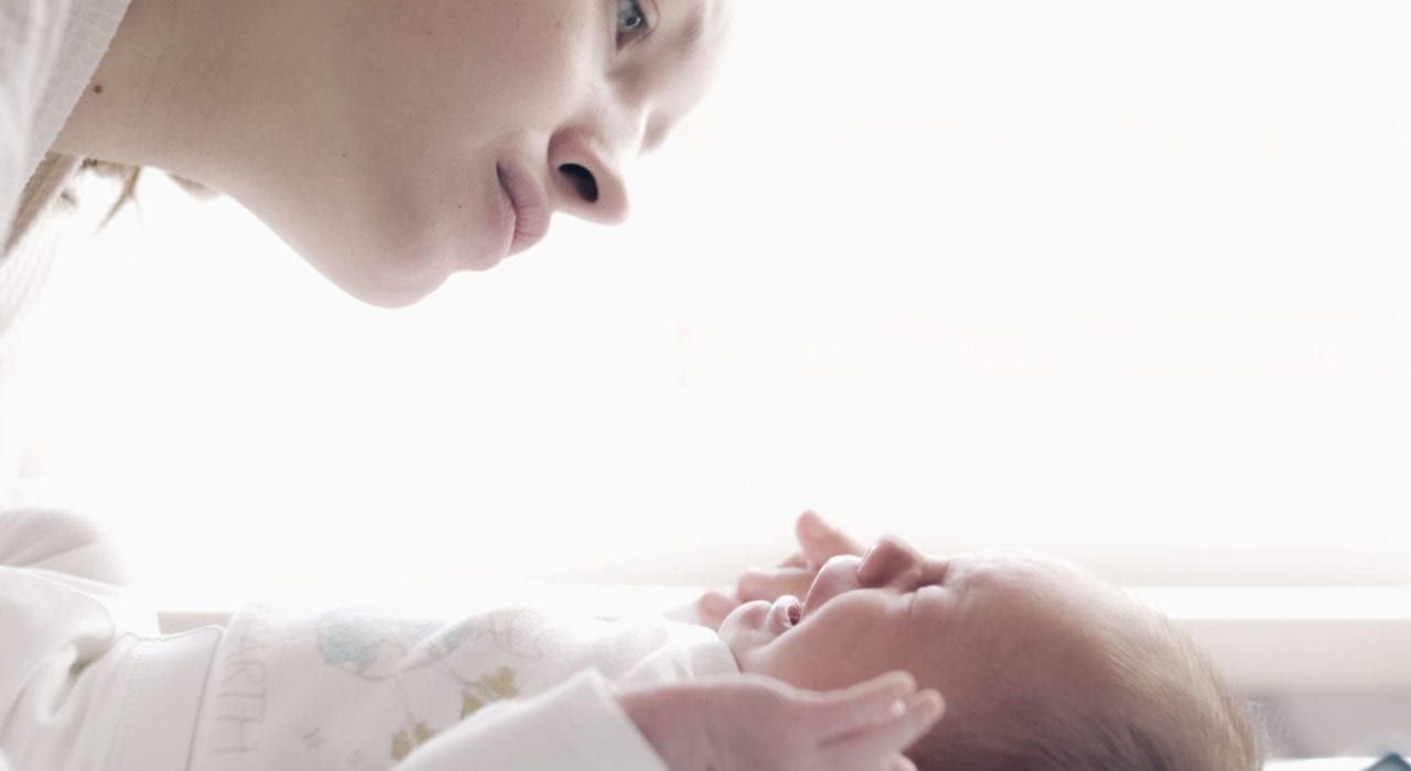 baby crying - mother comforting crying baby wondering what's wrong
