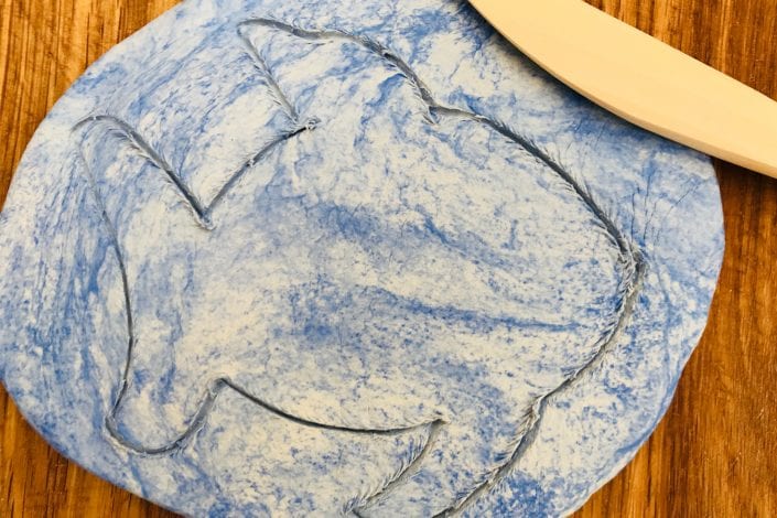 Kids Crafts - Rainbow Fish step 3 rolled out marbled clay and cut out shape of a fish