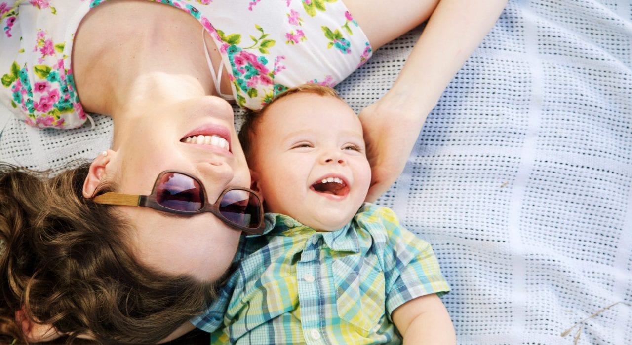Mum and baby having fun on a picnic mat