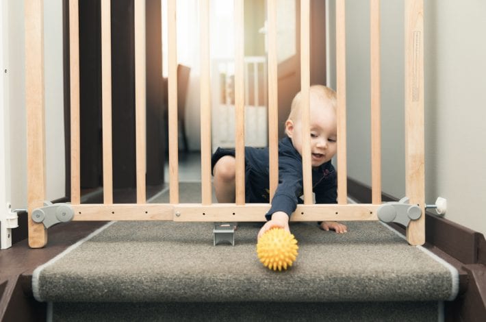 child next to stairgate baby proofing