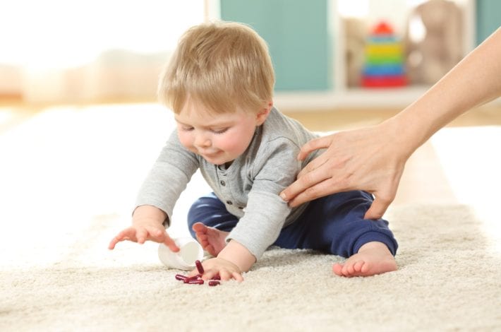 toddler about to eat pills - dangers in the home