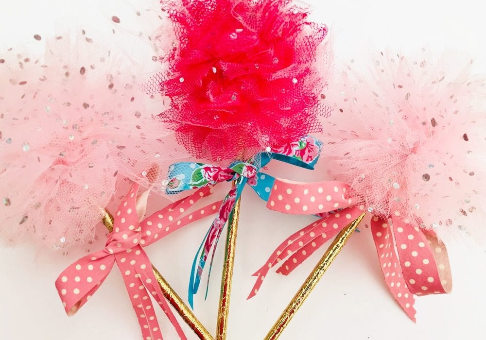 DIY princess party decorations - learn how to make tulle pom pom wands. Arrange tulle pom pom sticks in jars or as table decorations at kids parties.
